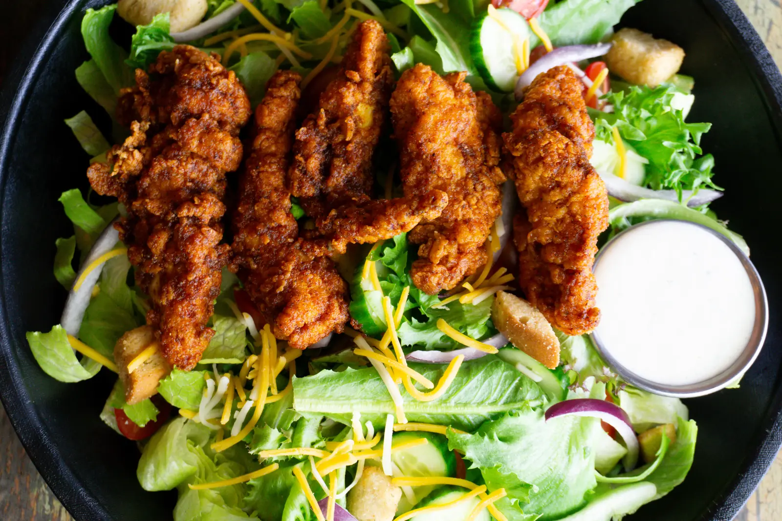 Lamon’s hot chicken tenders over a fresh salad with ranch